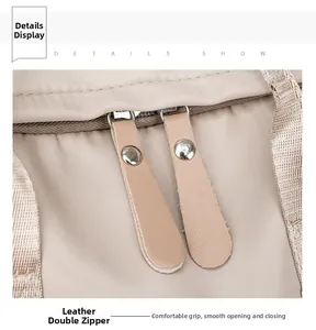 Detailaufnahme der robusten Doppel-Lederreißverschlüsse am beigen Nylon-Rucksackstoff