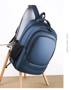 Close-up of a dark blue water-resistant travel backpack with multi-layer zipper pockets