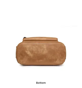 Vista inferior detallada de la mochila vintage marrón que muestra costuras y estructura sólida