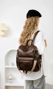 Detalle de mochila de cuero marrón vintage con correa de hombro tejida geométrica