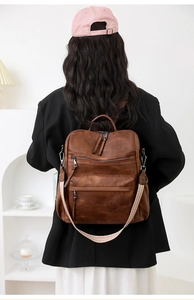 Detalle de la mochila de cuero marrón oscuro con textura retro y correa tejida étnica
