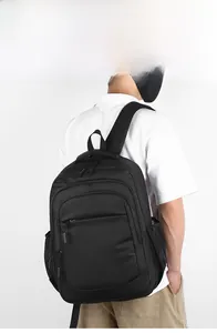 Close-up of black commuter backpack featuring multi-layer zippers and mesh side pockets