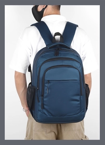 Detail view of large capacity navy blue business backpack with side mesh pockets on model