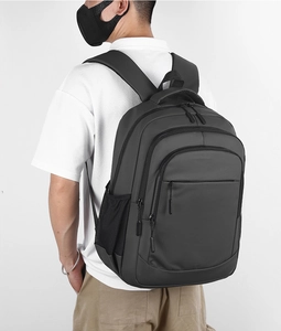 Macro detail of ergonomic padded straps on a durable dark grey business laptop backpack