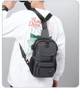 Detailed back view of a grey waterproof tactical crossbody bag worn by a model in outdoor style