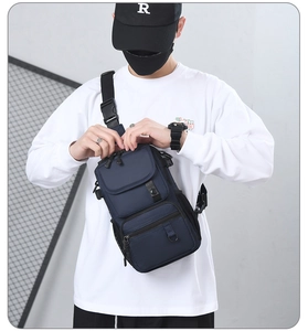 Detail of dark blue waterproof chest bag with multiple pockets and plastic buckle strap