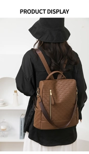 Rear view of model wearing a brown embossed PU leather anti-theft backpack with metal zips
