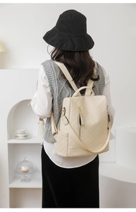 Close-up of off-white anti-theft backpack with geometric square embossing on a model