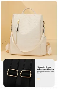 Detail view of adjustable black straps and gold buckles on cream geometric quilted backpack