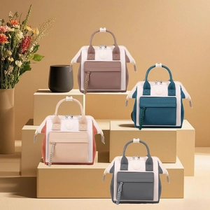 Detalle de cuatro mini bolsos cambiadores impermeables en nailon de colores con asas dobles