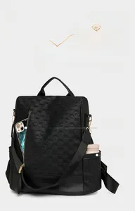Detail of black woven leather backpack showing front zipper pocket and side water bottle pouch