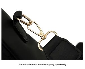 Close-up of detachable gold metal hooks and reinforced stitching on black leather bag