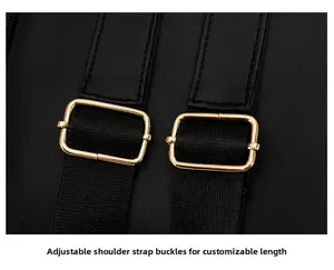 Detail of adjustable shoulder straps with gold metal buckles on a black travel backpack