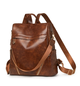 Macro detail of brown vintage PU leather backpack showing texture and golden hardware