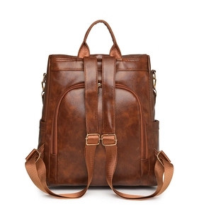 Detail view of vintage brown PU leather backpack with clear texture and gold-tone hardware