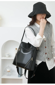 Detail view of large capacity black PU leather backpack showing fine texture and zippers