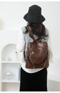 Detail of dark brown vintage PU leather backpack showing versatile straps and texture