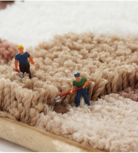 Close-up of thick moss-textured rug with dense shaggy fibers and reinforced edges