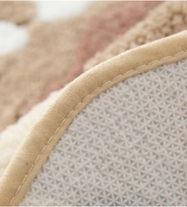 Detail of thickened faux sheepskin rug with secure stitched edges and non-slip backing
