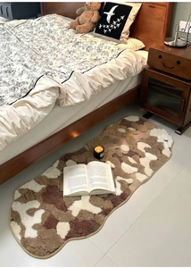 Detail view of thickened irregular moss rug with earth-toned plush texture in bedroom
