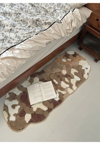 Irregular moss-style plush bedside rug with thick tufted texture in earthy color tones