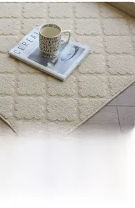 Macro detail of beige woven doormat with geometric rhombus texture on wooden floor