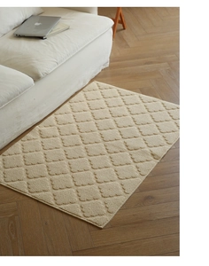 Close-up of cream rectangular rug with diamond tufted texture on wooden floor