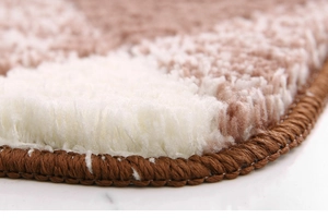 Detailed macro view of plush gradient rug with brown shag fibers and secure stitched edges
