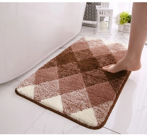 Detail of soft plush bathroom mat featuring a brown gradient diamond pattern by a bathtub