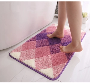 Close-up of thick flocked purple and pink diamond pattern bath mat by a bathtub