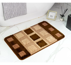 Detail van geblokte pluche badmat met dikke vezelstructuur en antislip op marmeren vloer