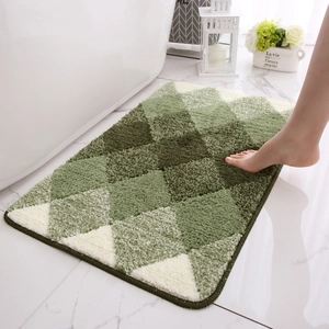 Green and white checkered plush bathroom rug next to a white bathtub with soft texture