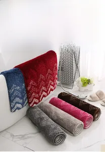 Detailed view of plush absorbent bath mats in multiple colors with soft wavy textures