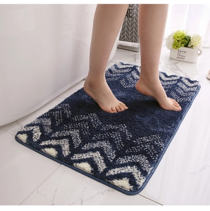 Detailed view of feet on soft navy blue gradient bath mat with white V-shape pattern