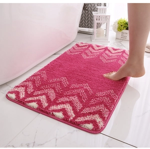 Close-up of thick pink chevron bath mat with soft absorbent flocking near a bathtub