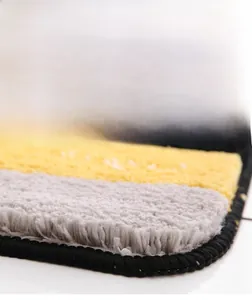 Detail of soft striped plush rug featuring thick texture and premium edge stitching