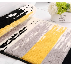 Close-up of thick flocked mat with modern yellow and grey abstract geometric pattern