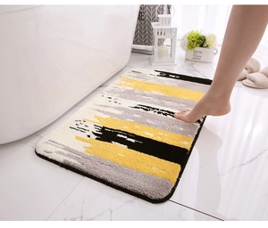 Detailed plush texture of thick absorbent bath mat with abstract yellow and grey stripes