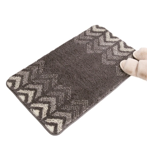 Gradient gray chevron plush rug with beige slippers on a minimalist white background
