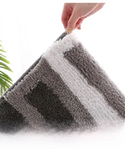 Detail of thick grey and white striped plush bath mat showing dense and soft fibers