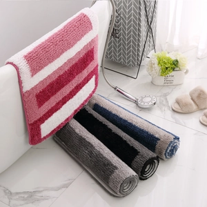 Absorbent striped plush bathroom rug set made of soft microfiber displayed in luxury bathroom