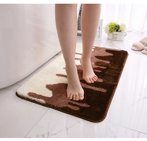 Close-up of thick non-slip bathroom mat with brown and white abstract ripple pattern