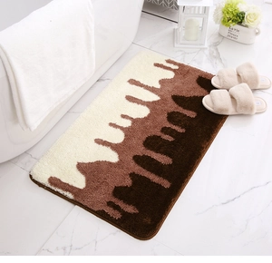 Macro view of thick plush bath mat featuring a three-color chocolate drip pattern design