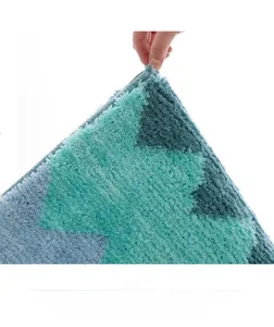 Gros plan du tapis de bain doux montrant la texture épaisse et les coutures bleu sarcelle