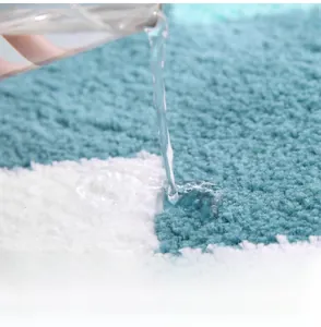 Gros plan d'un tapis de bain en microfibre montrant l'absorption d'eau et la texture