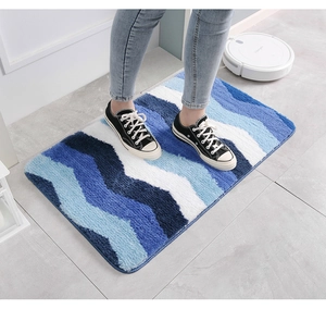 Détail de la texture douce du tapis de bain en microfibre à vagues bleues et blanches