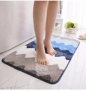 Gros plan d'un tapis de bain doux en microfibre à motifs de vagues bleues et blanches