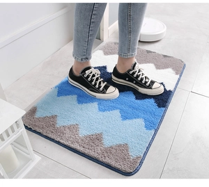 Vue détaillée du motif ondulé sur le tapis de bain rectangulaire en peluche bleu et gris
