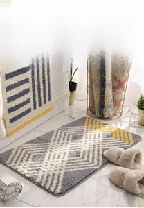 Gros plan du tapis de bain absorbant avec motif géométrique de losanges gris et jaunes