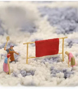 Gros plan des fibres épaisses du tapis de bain gris avec figurine de travailleur miniature